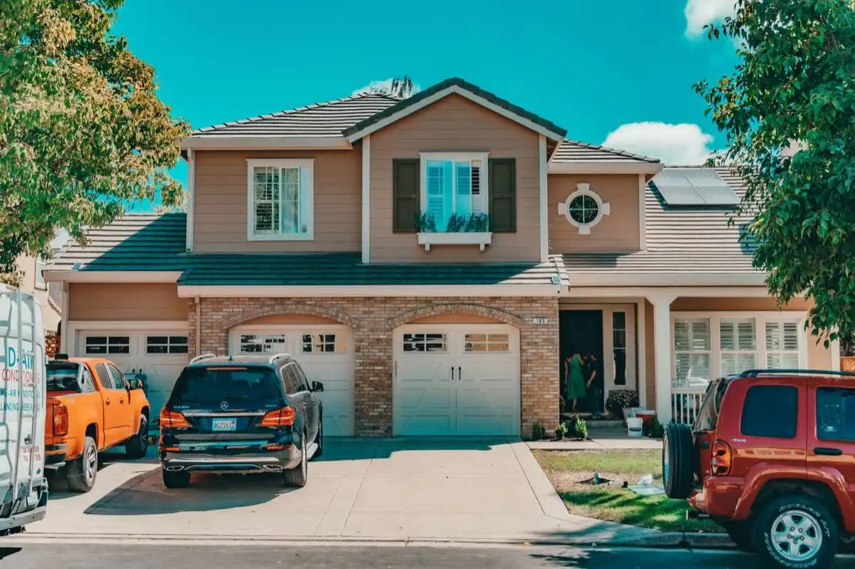 Two-story suburban house with double-hung windows, shutters and a garden window over the driveway